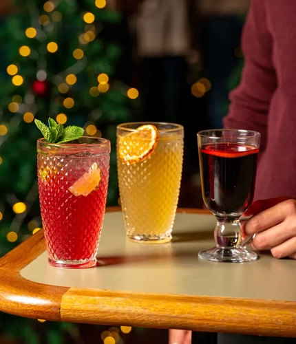 Two cocktails and a mug of mulled wine on a table.