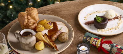 A banner showing several Festive Spread dishes sat on a table within the interior restaurant seating area at a Chef & Brewer venue.