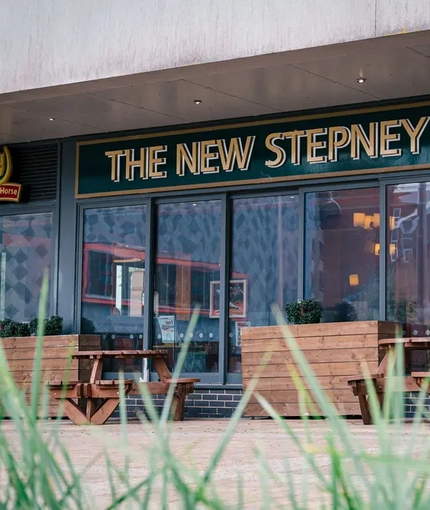 Exterior facade of a pub with a seating area.