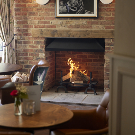 A seating area next to a roaring fire at the Little Harp.