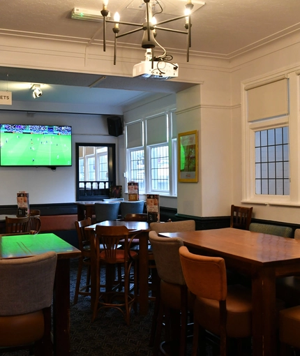interior dining area of a pub with a TV and a dartboard