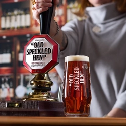 A Person serving a pint of Old Speckled Hen.