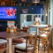The interior restaurant seating area with a TV on the wall and a pool table, at The Man On The Moon in Ipswich.