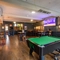 Interior dining area of a pub with a TV and a pool table.