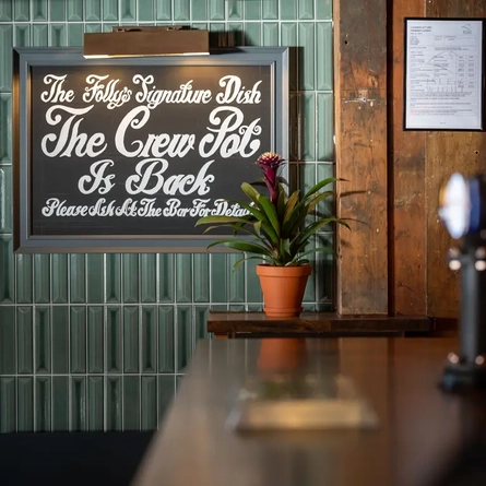 A sign advertising the Folly's signature dish, The Crew Pot