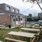 The exterior facade, signage, and beer garden seating area at The Longship in Hebburn, with wooden picnic tables, string lights overhead, and a TV on the wall.