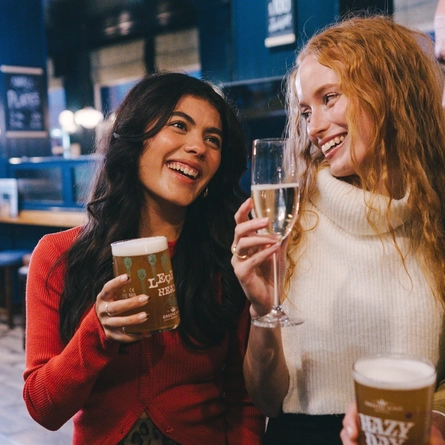 A lifestyle image of 3 friends stood at the bar enjoying various drinks within the interior of an Urban Core Venue.