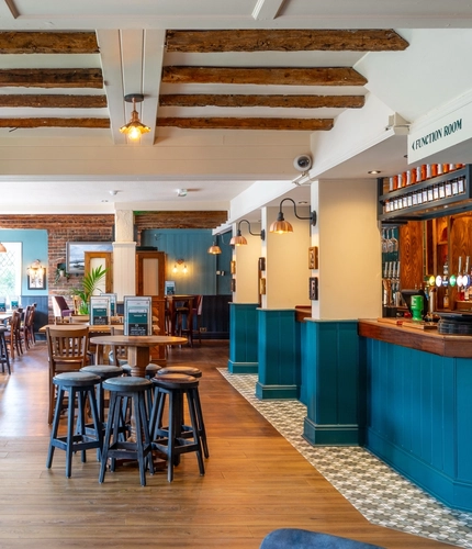 The bar and interior restaurant seating area at The Walkford, with wooden beams on the ceiling.
