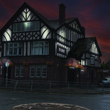 An artist impression illustration showing the exterior facade during the evening, lit up with hanging baskets at The Birkey.