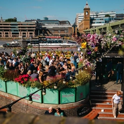 The outside of the Anchor, Bankside showing a full outdoor seating area/beer garden.