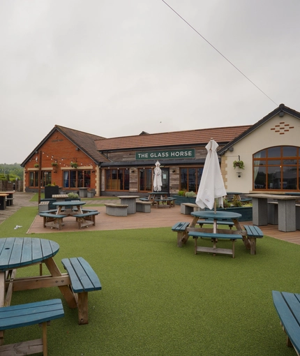 Exterior facade and beer garden of a pub with a play area.