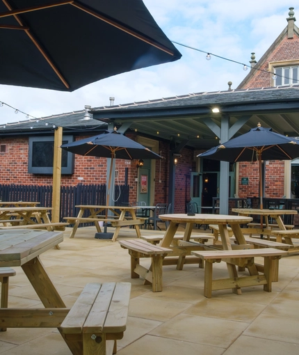 An image of the exterior beer garden seating area and partial undercover section with the rear of the venue in the background at The Guild.
