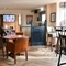 Interior dining area of a pub with a TV and a bar.