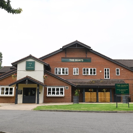 Exterior facade and car park of a pub.