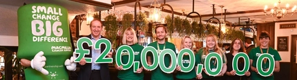 A group of people holding the results of fundraising for Macmillan