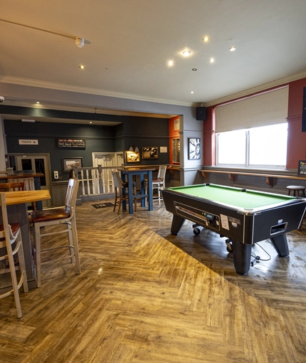Interior dining area of a pub with a TV.