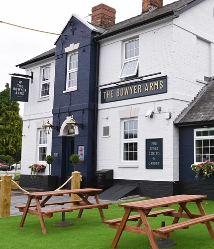 Exterior facade of a pub with a seating area.