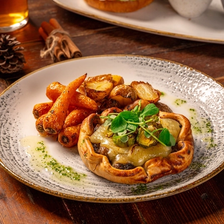 A plated Mushroom Galette on a plate on a wooden table.
