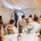 A man standing, ready to do a speech at a wedding reception.