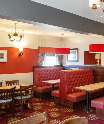 Interior dining area of a pub with TVs.