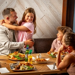 An image of a family enjoying a Sunday Roast and various drinks within the interior restaurant and seating area at a Hungry Horse venue.