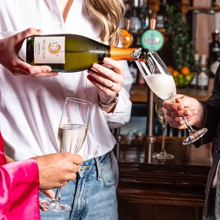 Guests sharing a bottle of fizz in the pub