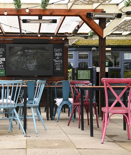 Exterior beer garden of a pub with a gazebo, a seating area and a TV.