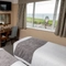 A interior twin hotel bedroom with two single beds, a dressing table with mirror and TV at The Commodore.