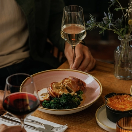 A lifestyle image of a bowled main dish from the Burns Night menu sat on a table within the interior restaurant seating area at The Crown.