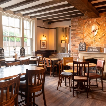 Interior dining area of a pub with a fireplace.
