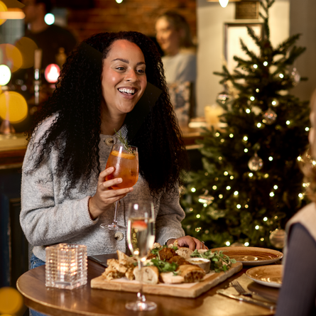 An image of 2 people enjoying a sharing platter and drinks within the interior restaurant and seating area at a Chef & Brewer venue.