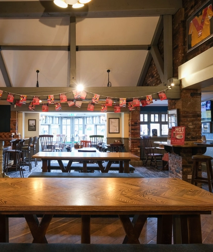 Interior dining area of a pub with a fireplace and a TV.