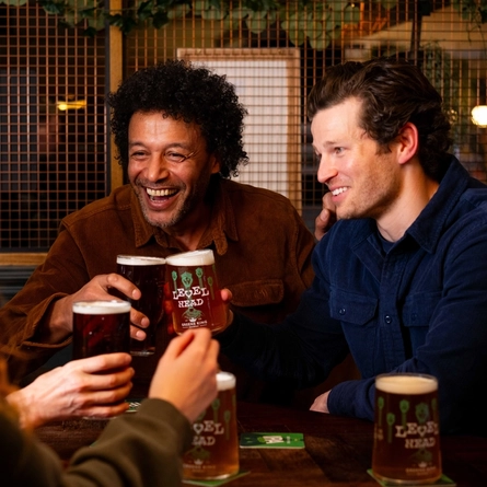A group of people enjoying a beer at a table.
