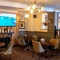 Interior dining area of a pub with a fireplace and a TV playing sports.