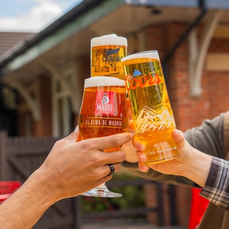 An exterior shot of people enjoying alcoholic drinks served in a beer garden at the Mill House in Stretton.