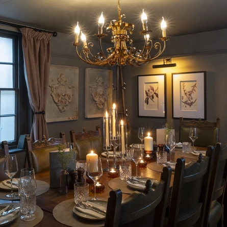 Function room with large table set up for a meal with a chandelier and a large window