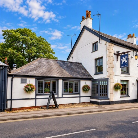 An image featuring the exterior facade of the venue with venue signage, hanging baskets, planters and lantern lighting at The Griffin.