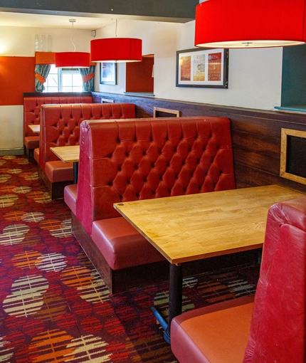 Interior dining area of a pub with TVs.