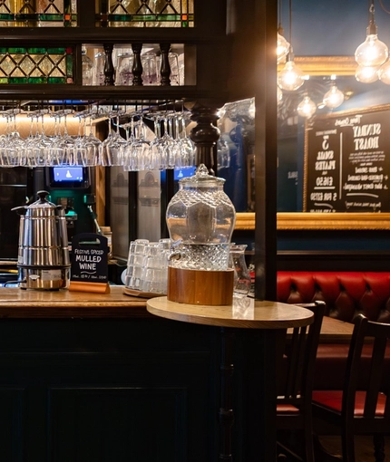 The interior bar with advertising signage and glass water dispenser at The Three Crowns.