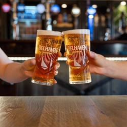 An image of 2 people holding a pint of Belhaven Belter each engaging in a cheers.