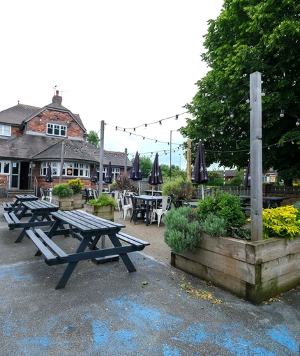Exterior beer garden of a pub with a seating area.