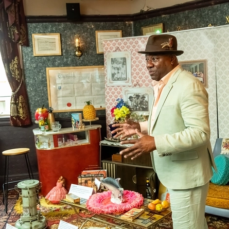 A historian 'Tony Fairweather' showing Greene King staff a staged Windrush Front Room during Black history month.