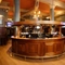 The wood panelled interior restaurant seating area and U-shaped bar at the Rhoderick Dhu in Glasgow; with upholstered booth seating, and TVs on the walls.