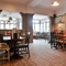 Interior dining area of a pub with a fireplace.