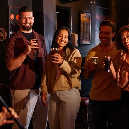 An interior shot of a group of people with various drinks during the Q3 Live Music Event at one of the Greene King Pubs.