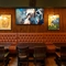 The interior seating area of Molly Malones, with upholstered seating, wooden tables, and TVs on the walls.