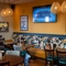 An interior restaurant seating area at The Kittoch, with a long upholstered booth seat, and a TV on the wall.