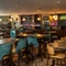 The bar and interior restaurant seating area of the Rudds Arms; with upholstered bar stool seating, and spherical lights above the bar.