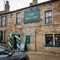 The exterior facade and signage of The Red Lion in Skipton, with a balloon arch around the front door.