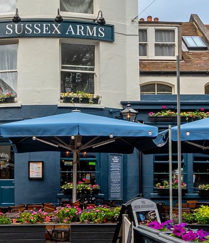 The exterior facade with seating area of The Sussex Arms in Brighton.